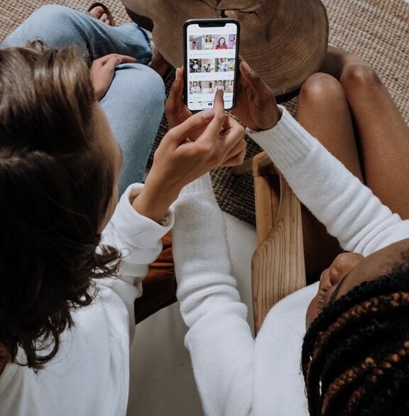 Zwei Personen, die ein Smartphone in den Händen halten.