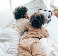 Zwei Kinder, die auf einen Laptop schauen.