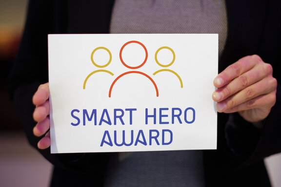 Zwei Hände halten das Smart Hero Award Logo in die Kamera  