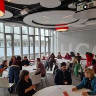 Menschen, die an Tischen sitzen und sich unterhalten.