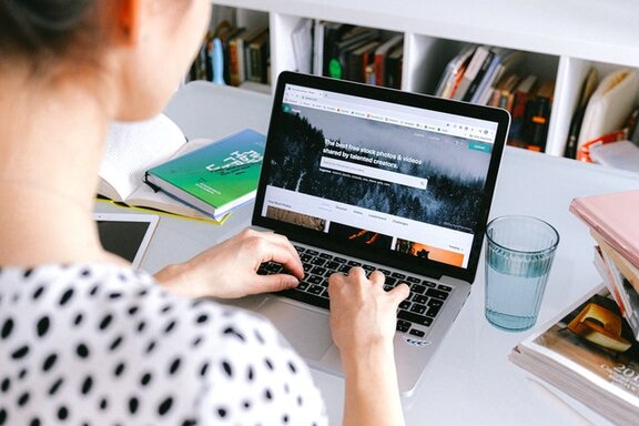 Eine Person, die an einem Laptop sitzt.