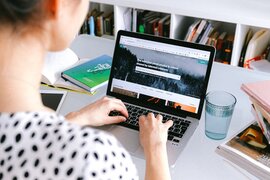 Eine Person, die an einem Laptop sitzt.