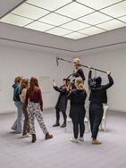 Menschen in einem Raum, die mit einem Mikrofon etwas aufnehmen.