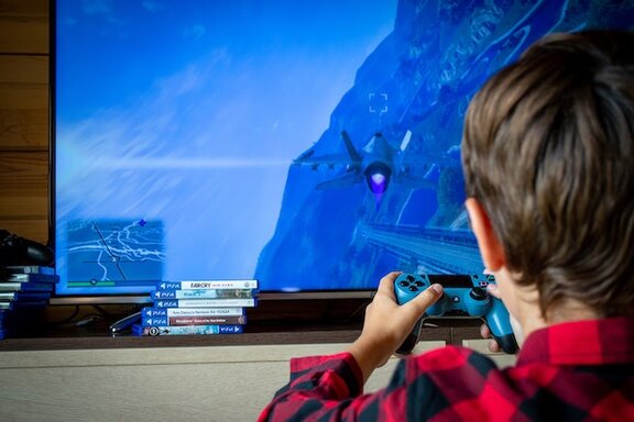 Ein Kind, dass einen Joystick in den Händen hat und spielt.