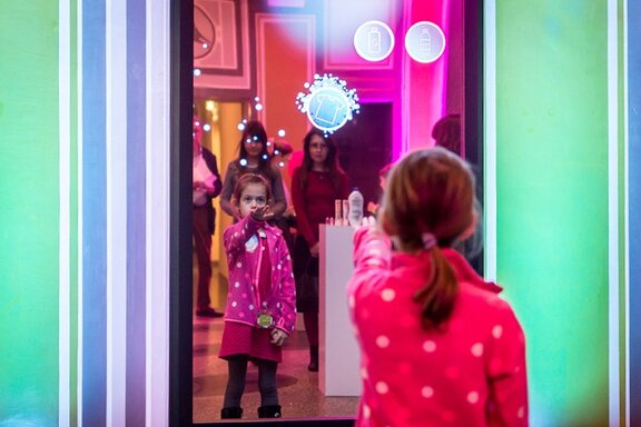 Ein Mädchen erkundet ein multimediales Spiel beim Multimediawettbewerb mb21.