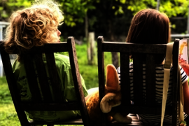 kinder, die auf Stühlen draußen sitzen