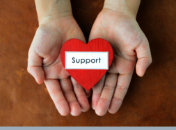 Eine Hand, auf der ein Herz mit der Aufschrift "support" zu sehen ist