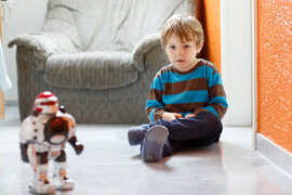 Kind spielt  mit Roboter