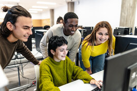 Das Bild zeigt 3 junge Menschen, die gemeinsam interessiert auf einen Computerbildschirm schauen.