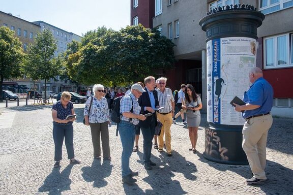 Seniorengruppe beim Digitalen Spaziergang in Charlottenburg neben der Litfaßsäule  