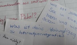 Fragen, die auf mehreren Papierblättern stehen.