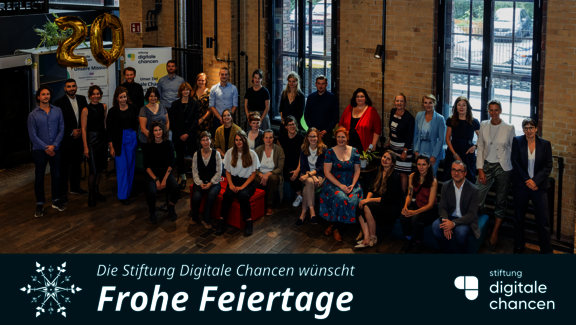 Weihnachtsgrußkarte der Stiftung: Das Stiftungsteam und der Vorstand der Stiftung, im Hintergrund ein "20" Luftballon. Darunter steht. Die Stiftung Digitale Chancen wünscht Frohe Feiertage  