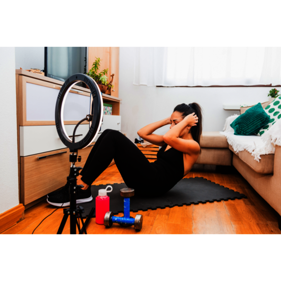 Eine Person, die Sportübungen vor einer Handykamera macht.