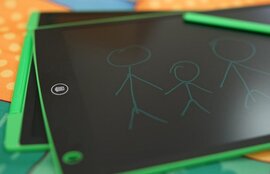 Auf einem Tisch liegen zwei Tablets, auf denen eine Strichmännchen-Familie gezeichnet wurde