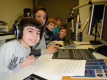 Kinder, die in einem Aufnahmestudio sitzen.