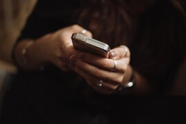 Eine Person, die ein Smartphon ein den Händen hält.