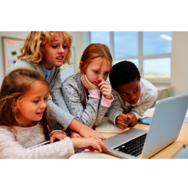 Kinder, die vor einem Laptop sitzen und Aufgaben bearbeiten.