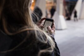 Ein Mensch, der eine Telefonnummer auf dem Smartphone wählt.