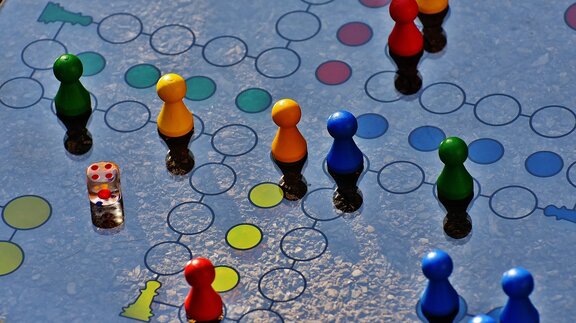 Ein Spielbrett mit Spielfiguren und Würfel