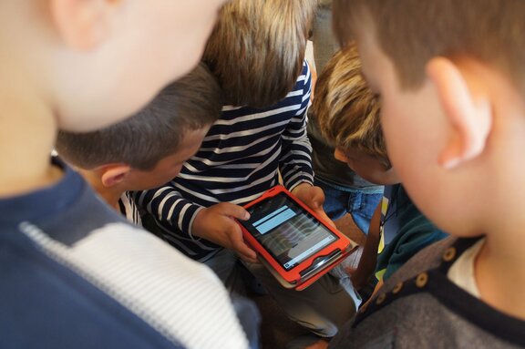 Kinder bedienen ein Tablet  