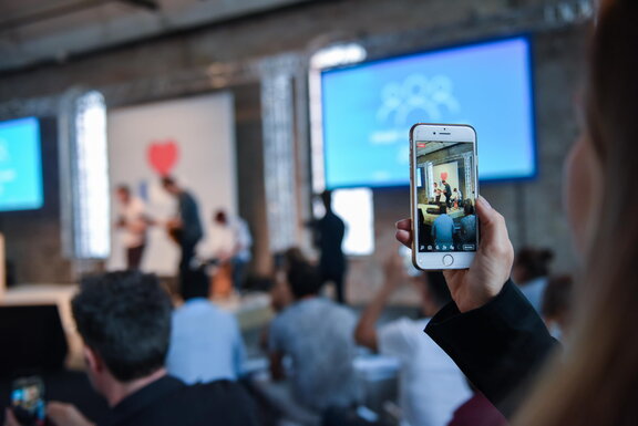 Foto einer die Bühne fotografierenden Zuschauerin bei einer vergangenen Preisverleihung  