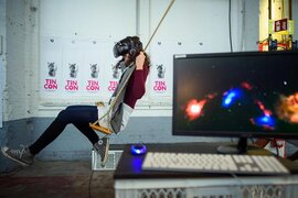 Eine Person, die auf einer Schaukel sitzt und eine VR-Brille trägt.