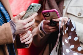 Zwei Menschen, die jeweils ein Smartphone in den Händen halten.