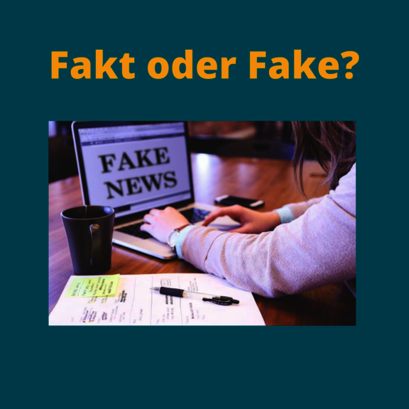 Schreibtisch mit Laptop, auf dem Fake News zu lesen ist