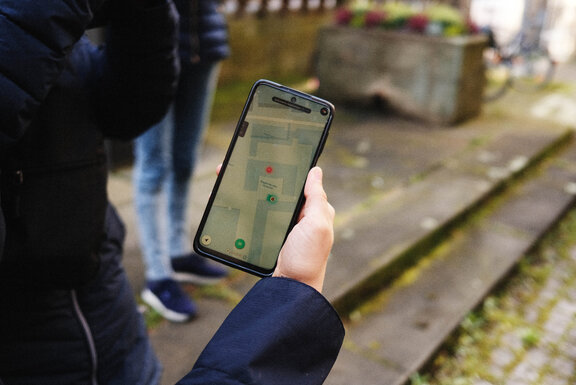 Eine Person, die ein Smartphone in der Hand hält.