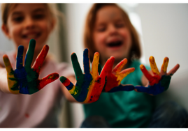 Kinder, die ihre Hände bunt angemalt haben.
