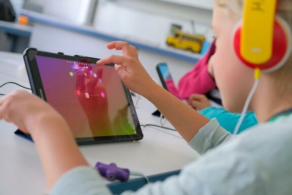 Mädchen mit Tablet und Kopfhörern  