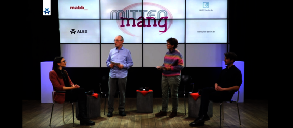 Talkshow Setting auf der Bühne des ALEX Berlin Studios: Dr. Carina Vorisek und Matthias Röck sitzen, in der Mitte stehen die beiden mittenmang Moderator*innen