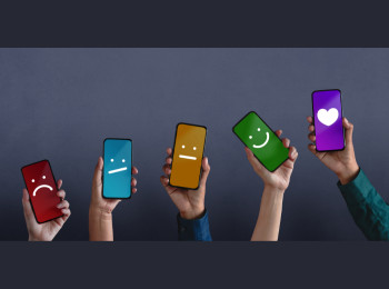 Hände, die Smartphones nach oben halten, auf denen traurige, unzufriedene sowie lachende Smilieys zu sehen sind.