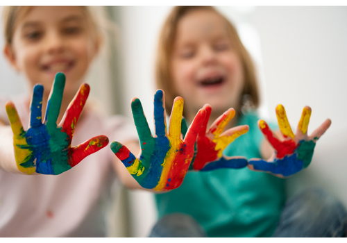 Kinder, die ihre Hände bunt angemalt haben.