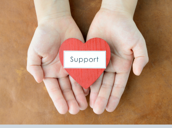 Eine Hand, auf der ein Herz mit der Aufschrift "support" zu sehen ist