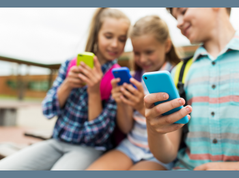 Kinder, die Smartphones in ihren Händen halten und auf diese schauen.